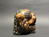 a close up of a figurine of a lion on a gray background