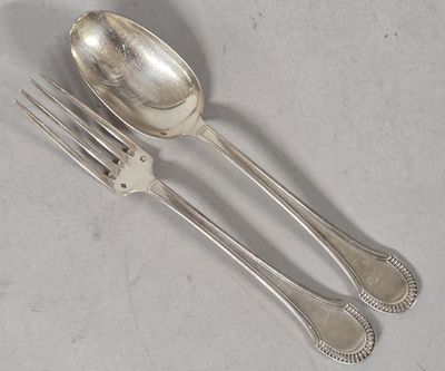 two forks and a spoon sitting on a table