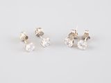 a pair of diamond stud earrings on a white background