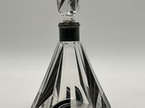 a close up of a glass perfume bottle with a black top