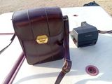 un sac en papier brun posé sur une table, à côté d'un appareil photo