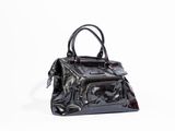un sac à main noir posé sur une surface blanche