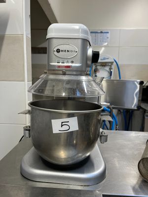 a silver mixer sitting on top of a counter in a kitchen