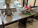 a kitchen counter with a mixer on it in front of a window