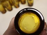a person holding a bottle of yellow liquid in their hand