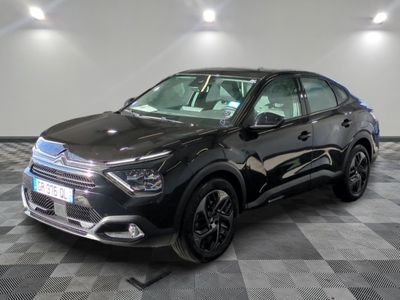 la voiture noire est garée dans le garage sur un sol en damier