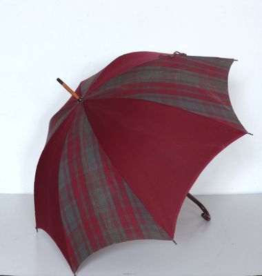 un parapluie rouge et gris posé sur une surface blanche