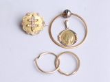 deux bagues en or et un pendentif en or sur lequel est représenté le visage d'une femme