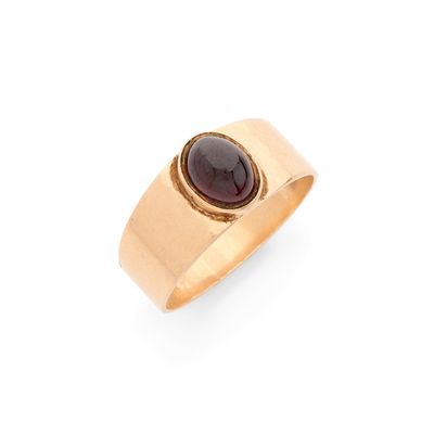 un gros plan d'une bague en or sertie d'une pierre de type grenatite