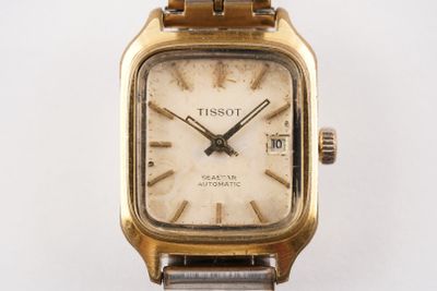 a close up of a wrist watch on a white surface