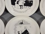 four plates with cartoon drawings on them are on a table