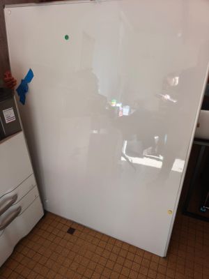 un réfrigérateur blanc dans une cuisine, à côté d'une machine à laver