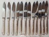 six knives and six knives on a white table