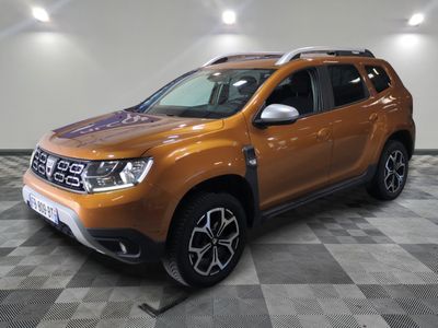 the orange dacia is parked on a checkered floor in a showroom