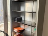 a metal cabinet with many items in it in the room