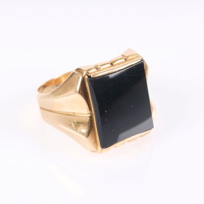 l'image d'une bague en or ornée d'une pierre noire