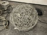 a ball of wire sitting on the floor next to a computer mouse