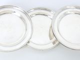 trois assiettes plaquées argent sur fond blanc