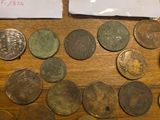 some old coins are sitting on a wooden table next to a piece of paper