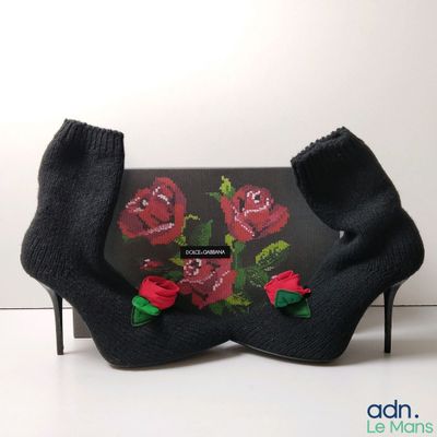 a black purse with red roses on it and a pair of black socks
