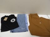 three pairs of men ' s nike sweatpants and a t - shirt on a table