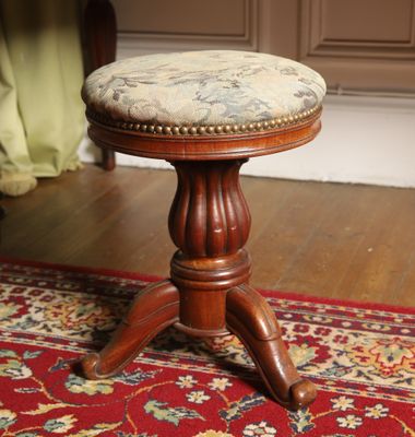 a small wooden stool with a cushion on top of it