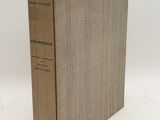 a brown book sitting on top of a white table next to a white wall