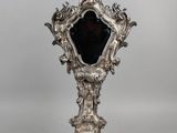 un miroir ancien plaqué argent, orné d'un verre noir au centre