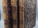 trois vieux livres sont empilés sur une table