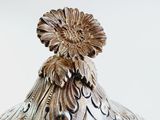 a silver vase with a flower on top of it