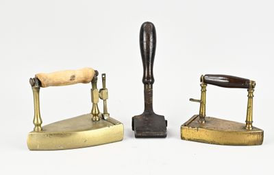 trois types différents de fers en laiton vieilli posés sur une surface blanche