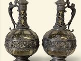 deux vases en argent posés l'un à côté de l'autre sur une table