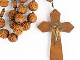 rosary and wooden cross on white background with copy space for text