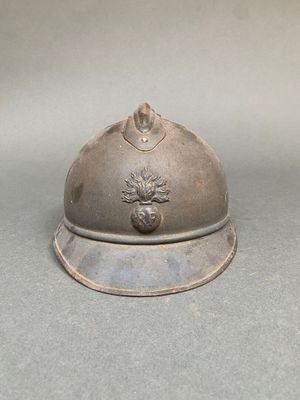un casque en argent orné d'un pin, posé sur une table