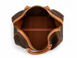 the inside of a brown and tan handbag on a white surface