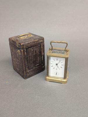 une petite horloge en métal posée à côté d'une petite boîte en bois