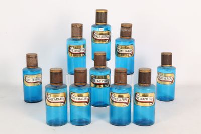 six bouteilles bleues avec des bouchons marron sont alignées sur une surface blanche