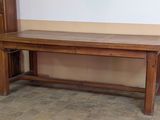 une table en bois avec un banc en dessous, dans une pièce