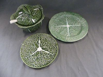 trois plats en céramique verts et blancs ornés de feuilles, posés sur une table
