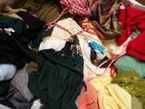 a pile of clothes that is sitting on a bed