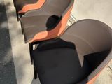 Plusieurs chaises sont alignées en rang sur le trottoir