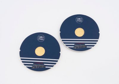 paire de dessous de verre ronds à rayures bleues et blanches et ornés d'un point doré
