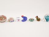several glass birds are lined up in a row on a white surface