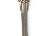 a silver fork with a knot on it on a white surface