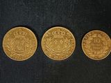 trois souverains d'or sur fond noir
