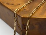 a close up of a wooden box with gold chains on it