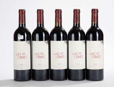 cinq bouteilles de vin sont alignées sur une surface blanche