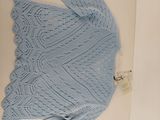a picture of a blue knitted sweater in a box