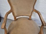 a brown chair sitting on top of a cement floor next to a wall