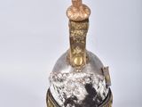 une image représentant une bouteille surmontée d'une plume
